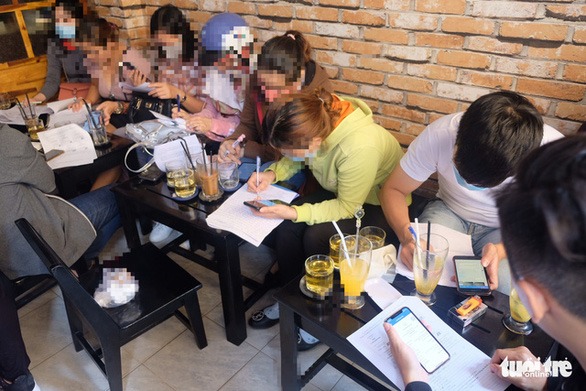 Nhóm người mua gói bảo hiểm 100% vốn đầu tư của Coolcat đang viết đơn tố cáo - Ảnh: BÔNG MAI